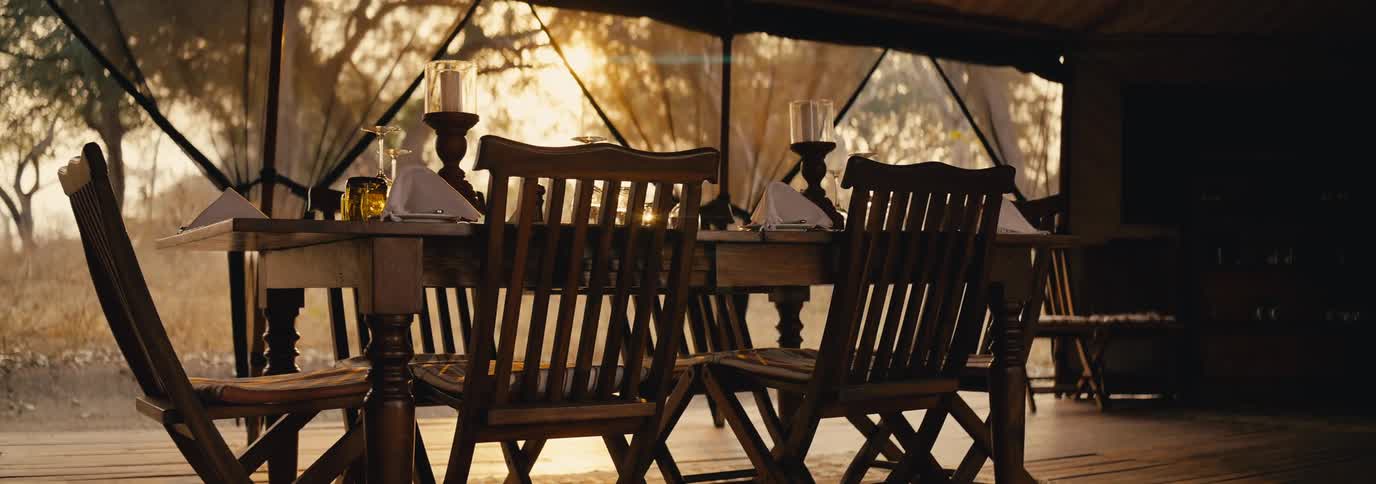 Interior design of a wooden table arranged with glasses and cutlery in a country house