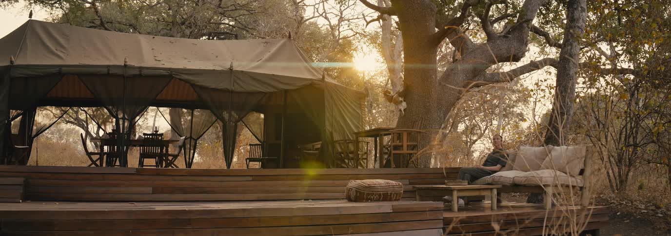 A woman is sitting outside the large tent