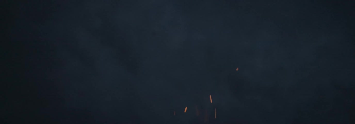 Embers from flames burning rising in the dark