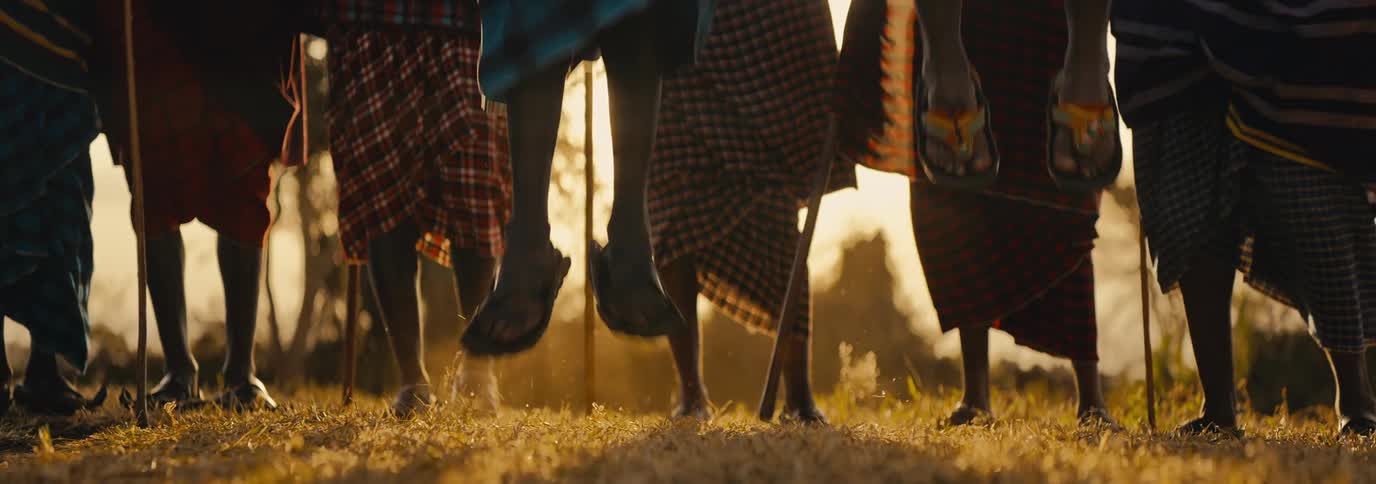 Group of people in traditional clothes jumping in a field