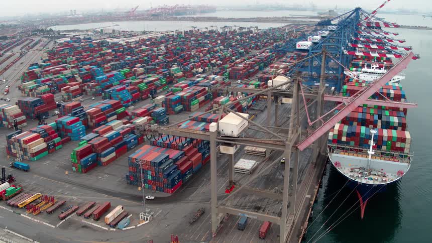 Aerial of a cargo ship docked at a  Los Angeles container port area during daytime