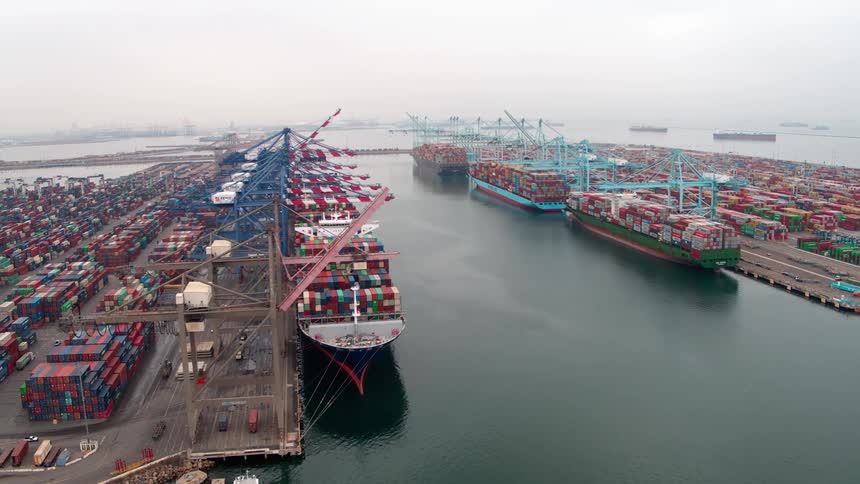 Aerial view of a busy  Los Angeles shipping port with docked cargo ships and containers