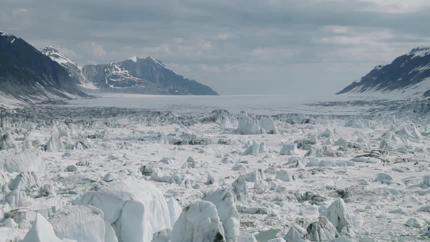 Frozen landscape with ice formations between snow covered mountains