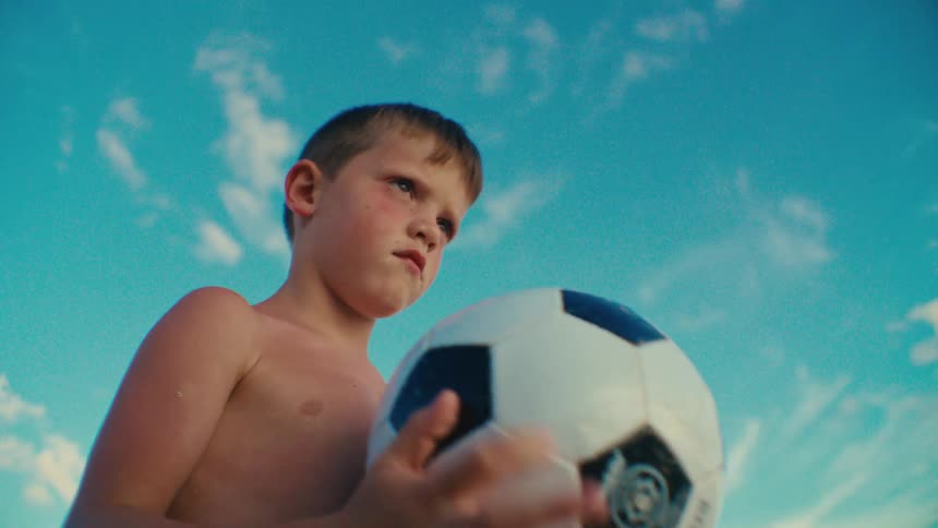 A boy spins a soccer ball in his hands