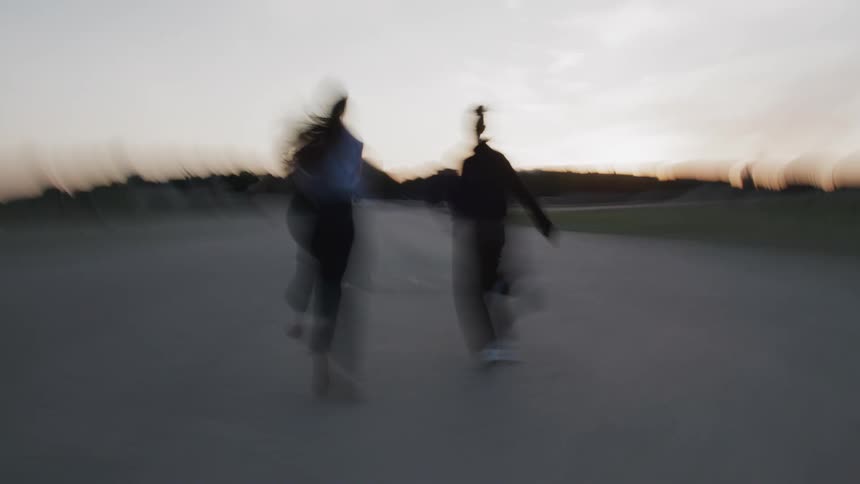 Silhouette of two women running outdoors