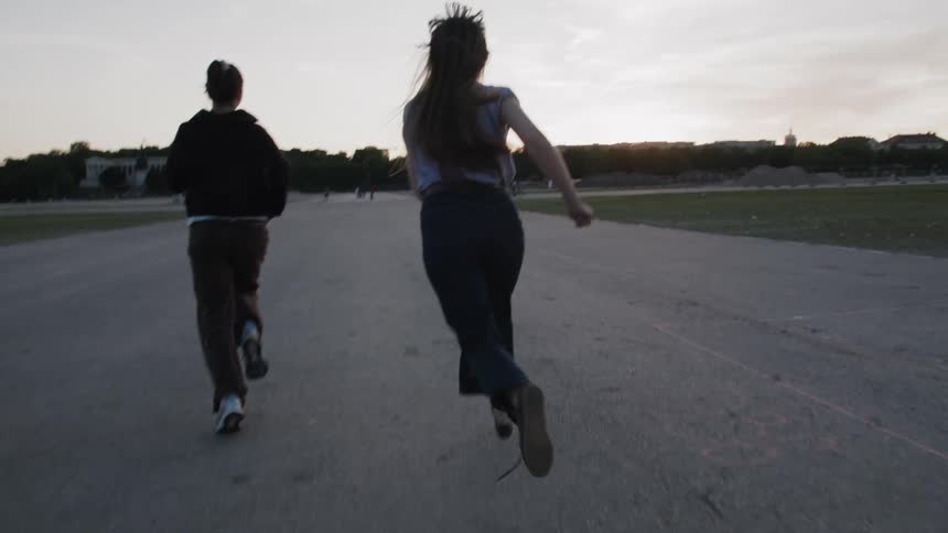 Two girls race together in the dirt