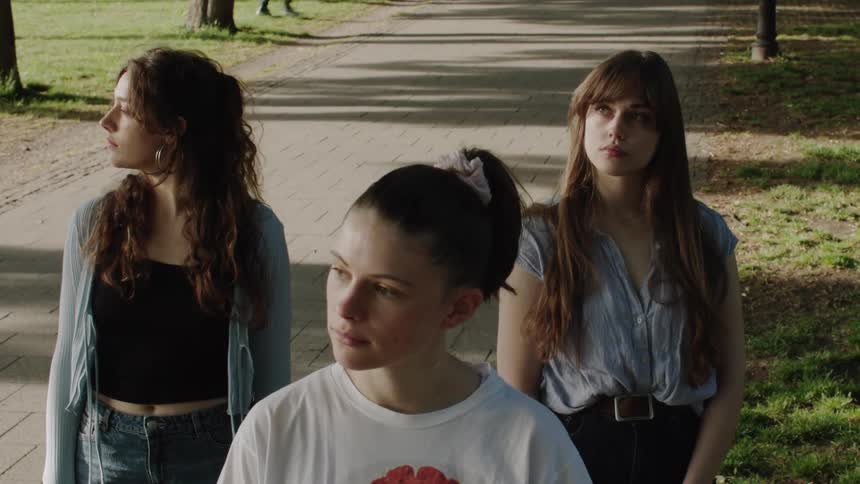 Three women in a park looking in the same direction