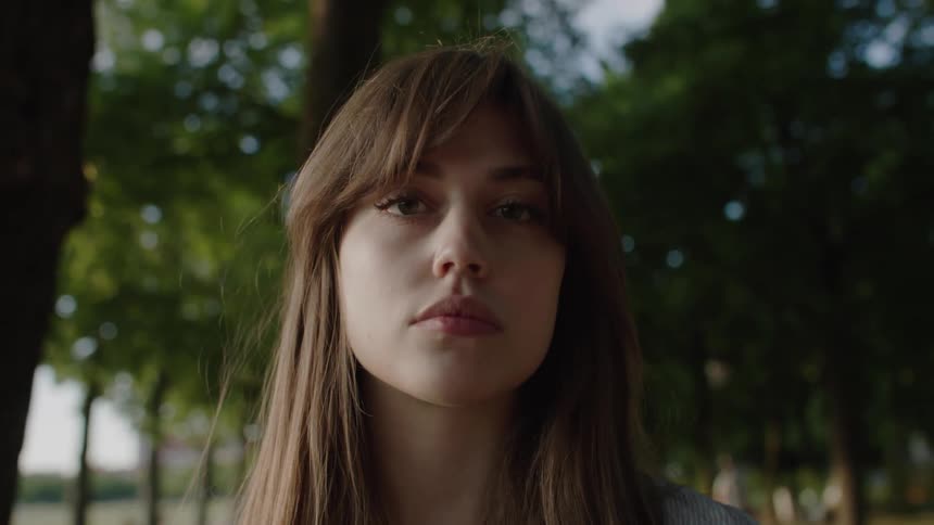 Young woman with brown hair looks into the camera