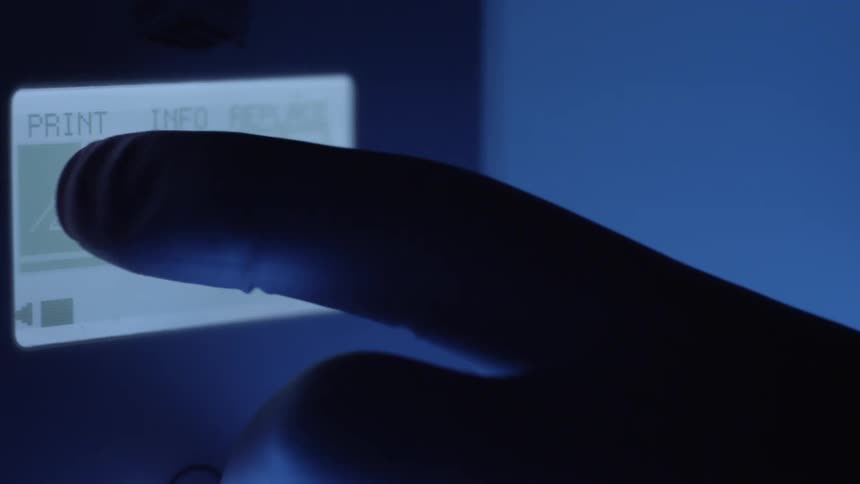 A person presses the touch screen on the printer
