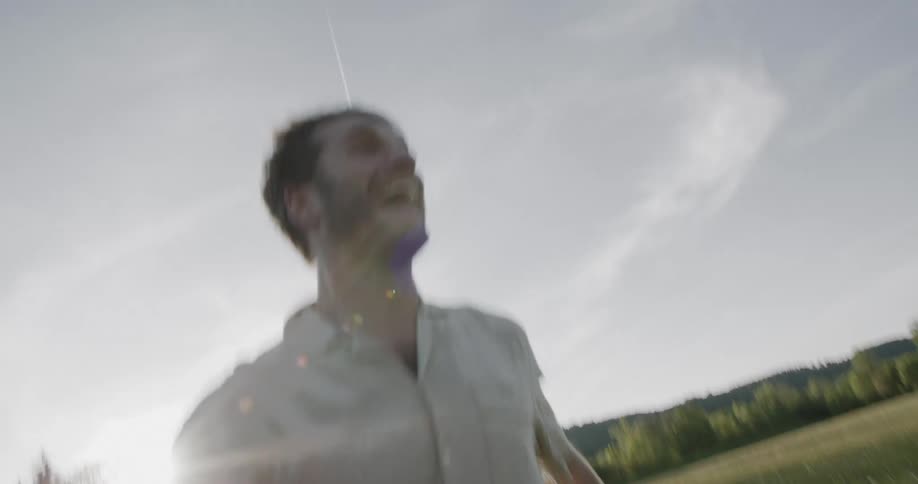 A joyful man runs through a sunlit meadow enjoying the outdoors