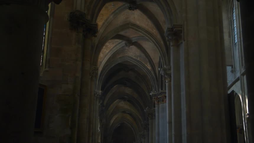 The arched interior of a building stands in muted light