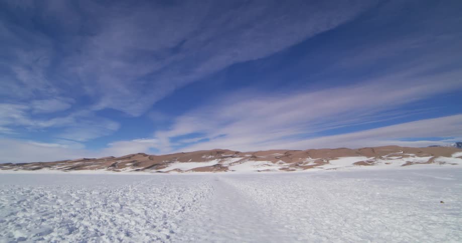 Snow covers the ground in the wilderness with mountains in the distance