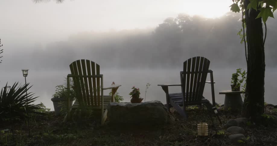 Two chairs overlooking a foggy lake