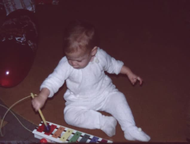 A child bangs on a colored musical toy