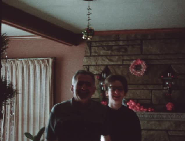 A man and woman kiss under the mistletoe