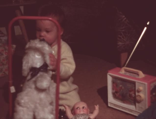 A baby plays with christmas presents
