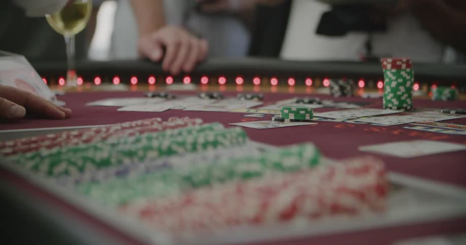 A dealer at a casino table places chips and deals a card