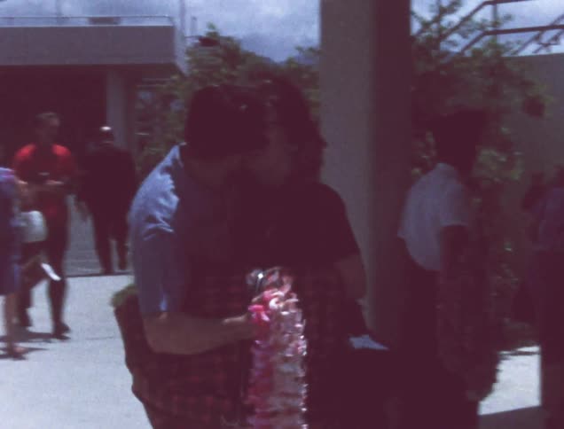A man and woman hug and kiss as they greet each other