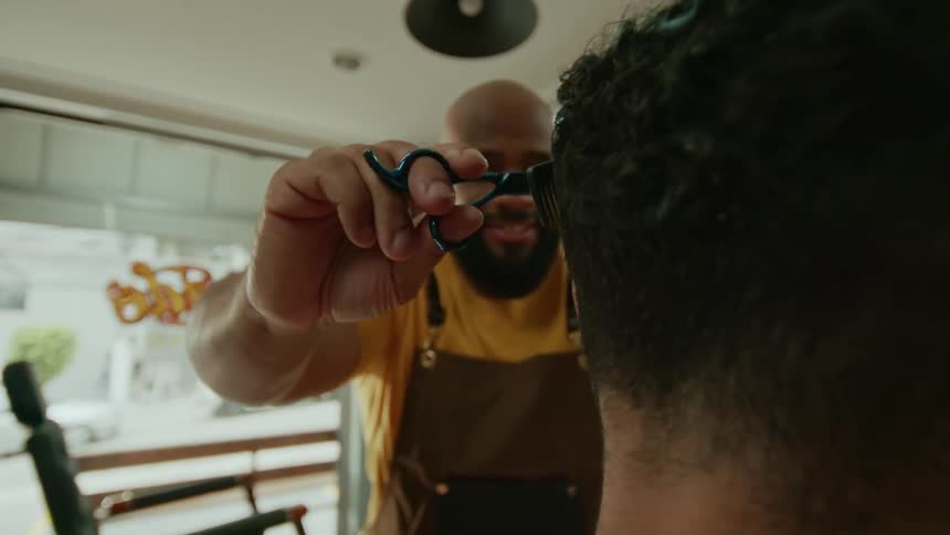 Barber cutting a customers hair with scissors and comb