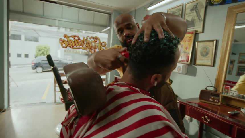 Barber shaving back of clients neck with electric shaver