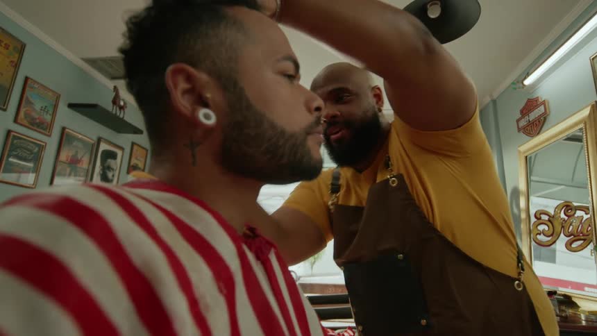 The customer is having a conversation as he gets a haircut