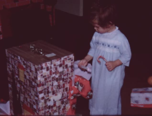 Little girl ripping wrapping paper off of a present