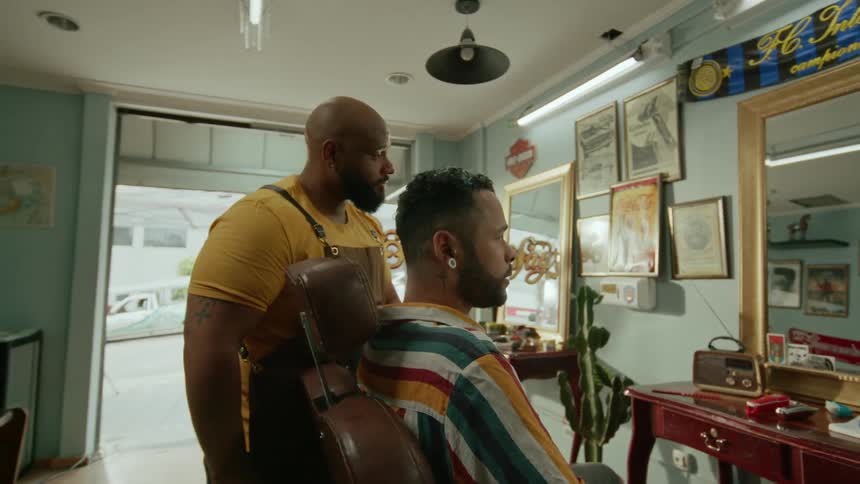 The barber talks with a customer in the barber chair