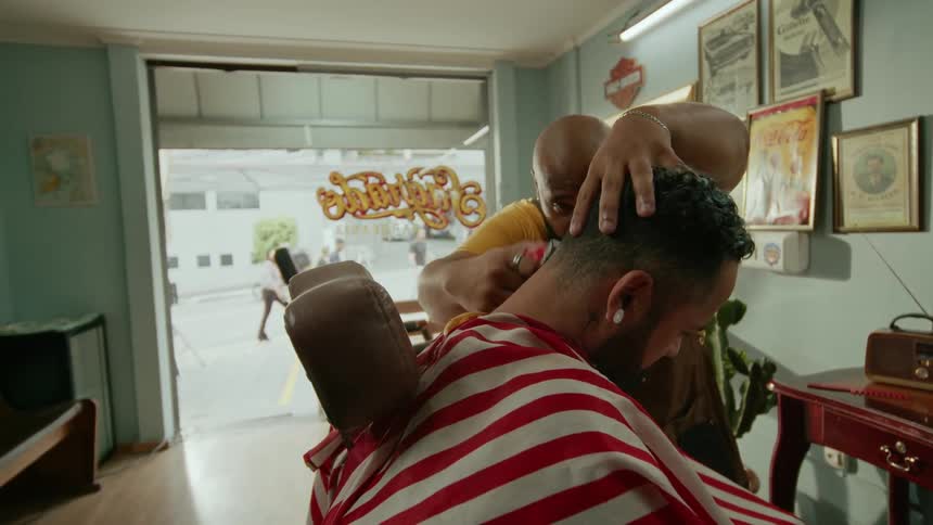 A barber trims a customer hair in a vintage barbershop