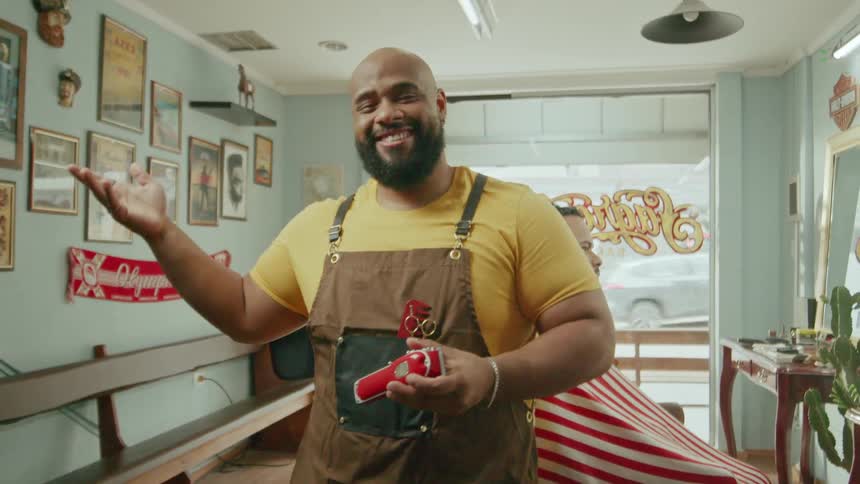 Proud happy barber showing off his barber shop