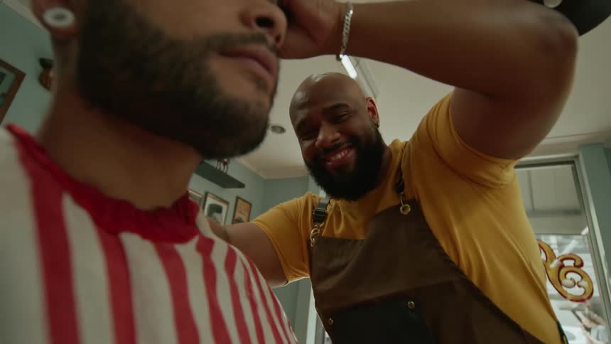 A man is laughing while he cuts hair