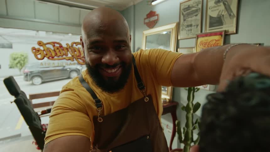 A barber trims a clients hair inside a stylish barbershop