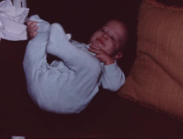 A baby shakes his head and looks around