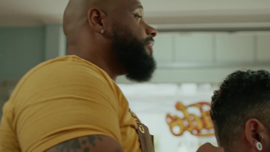 The barber prepares his customer for a haircut