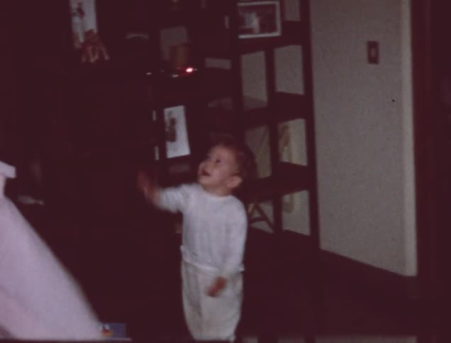 A toddler in pajamas plays with a balloon
