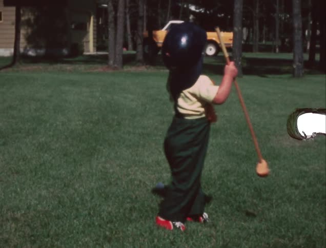 A young child plays with a mallet and ball