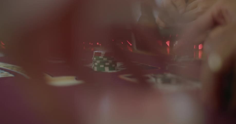 People sit at a casino table playing a card game