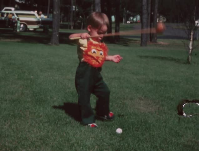 A boy is playing some golf in the yard