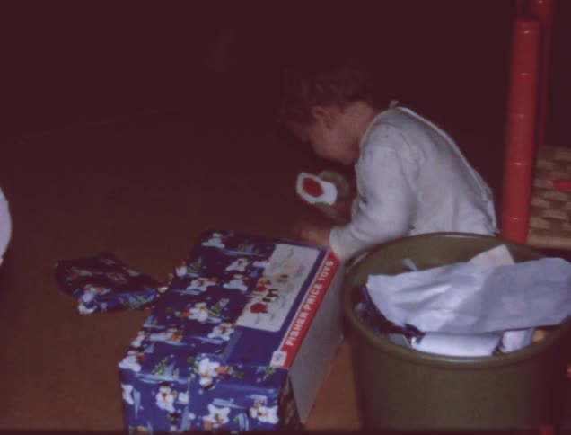 A young child rips the wrapping off a present
