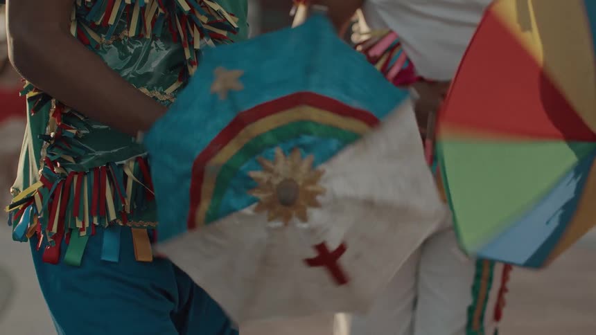 The dancers in costume line up with umbrellas