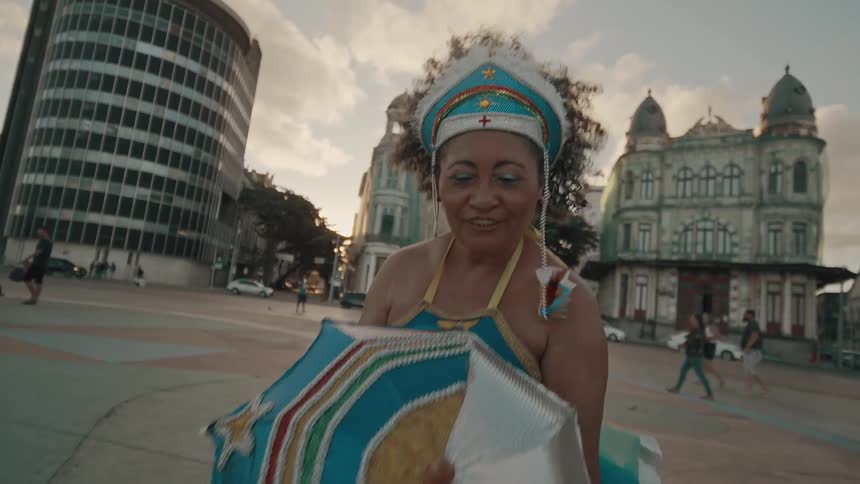 Costumed woman carrying an umbrella is dancing in the city