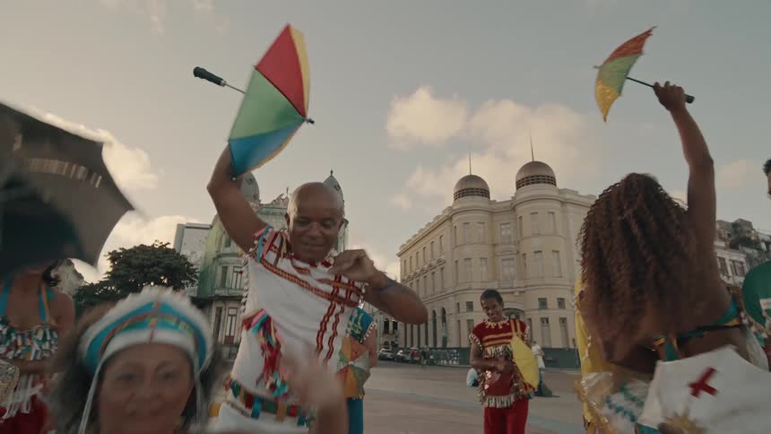 Samba group in typical and colorful clothes dancing in a square in the city