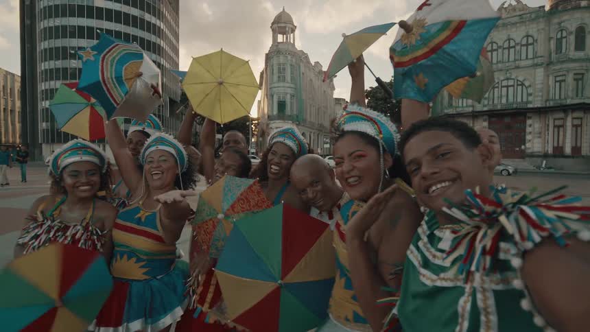 Dancers are smiling and twirling umbrellas