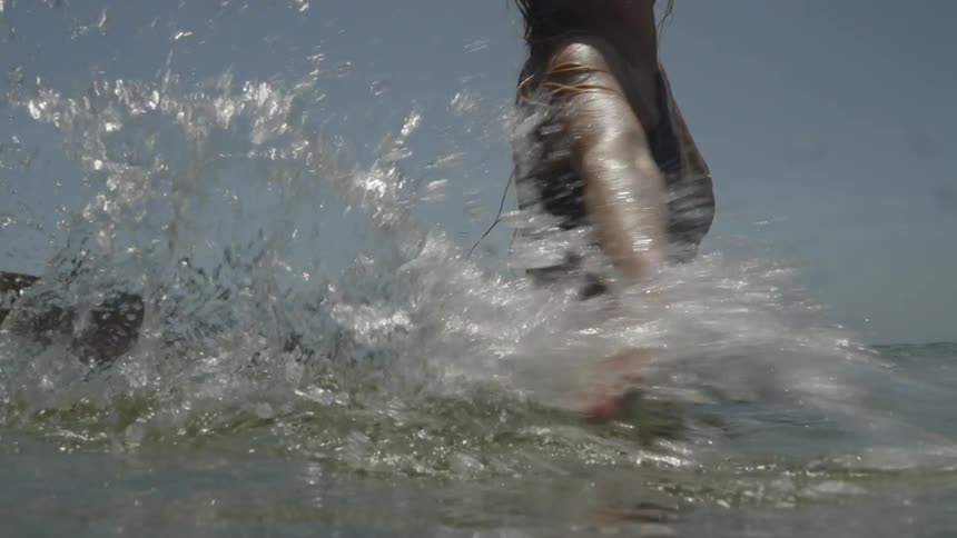 Lady splashes water while standing in the sea in the evening