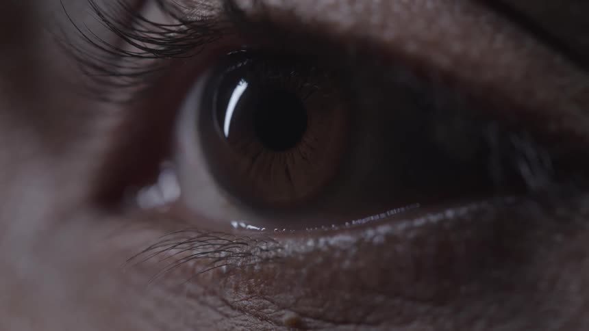 A person blinks their brown eye