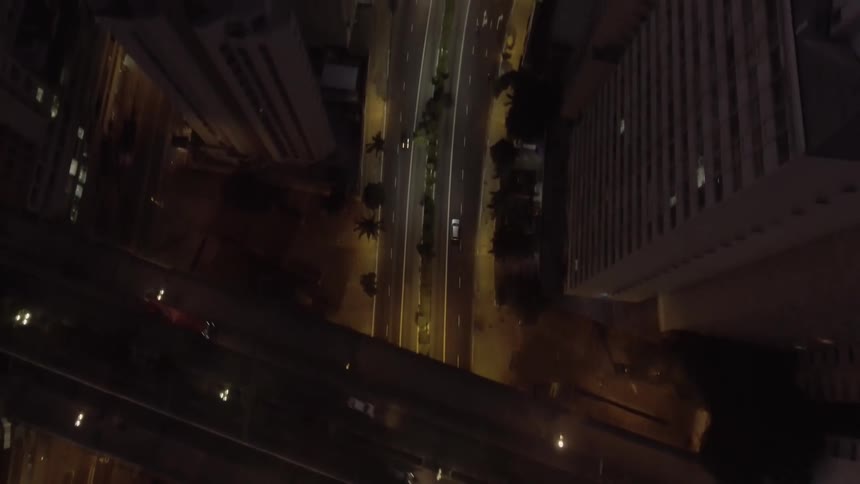 Aerial of moving cars and skyscrapers in a metropolitan area at night