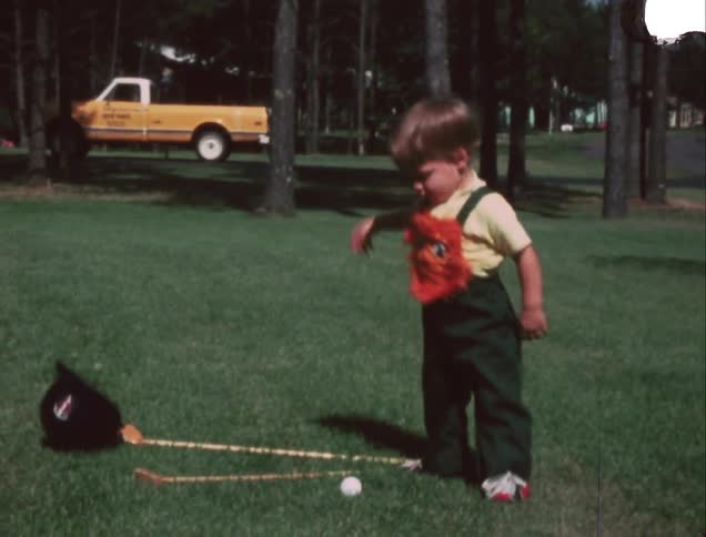 A young boy takes off a helmet and throws it onto the ground