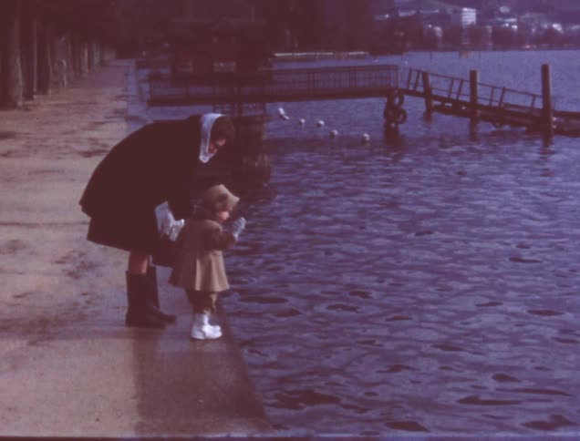 A woman and child watch the birds in the water
