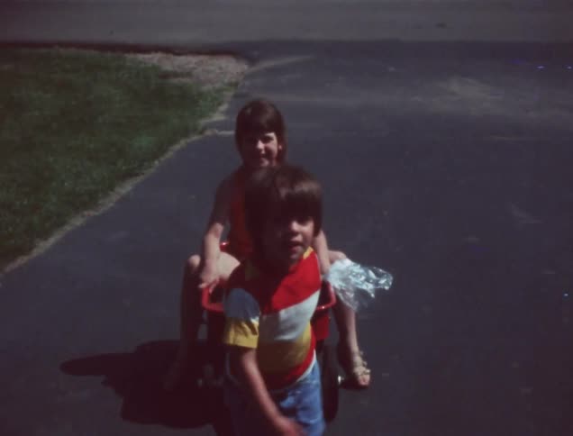 A young boy pulls a girl in a wagon
