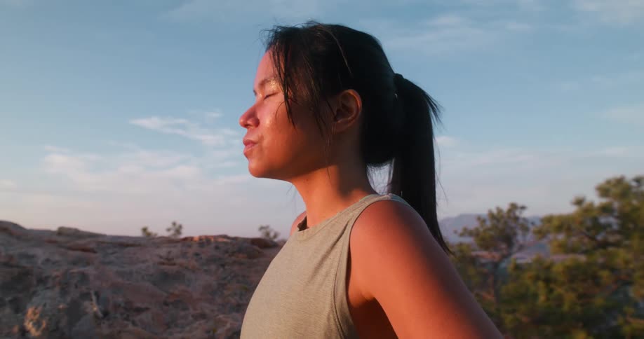 Woman in an outdoor environment and taking a deep breath