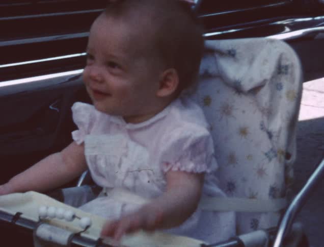 A baby girl sits in a highchair